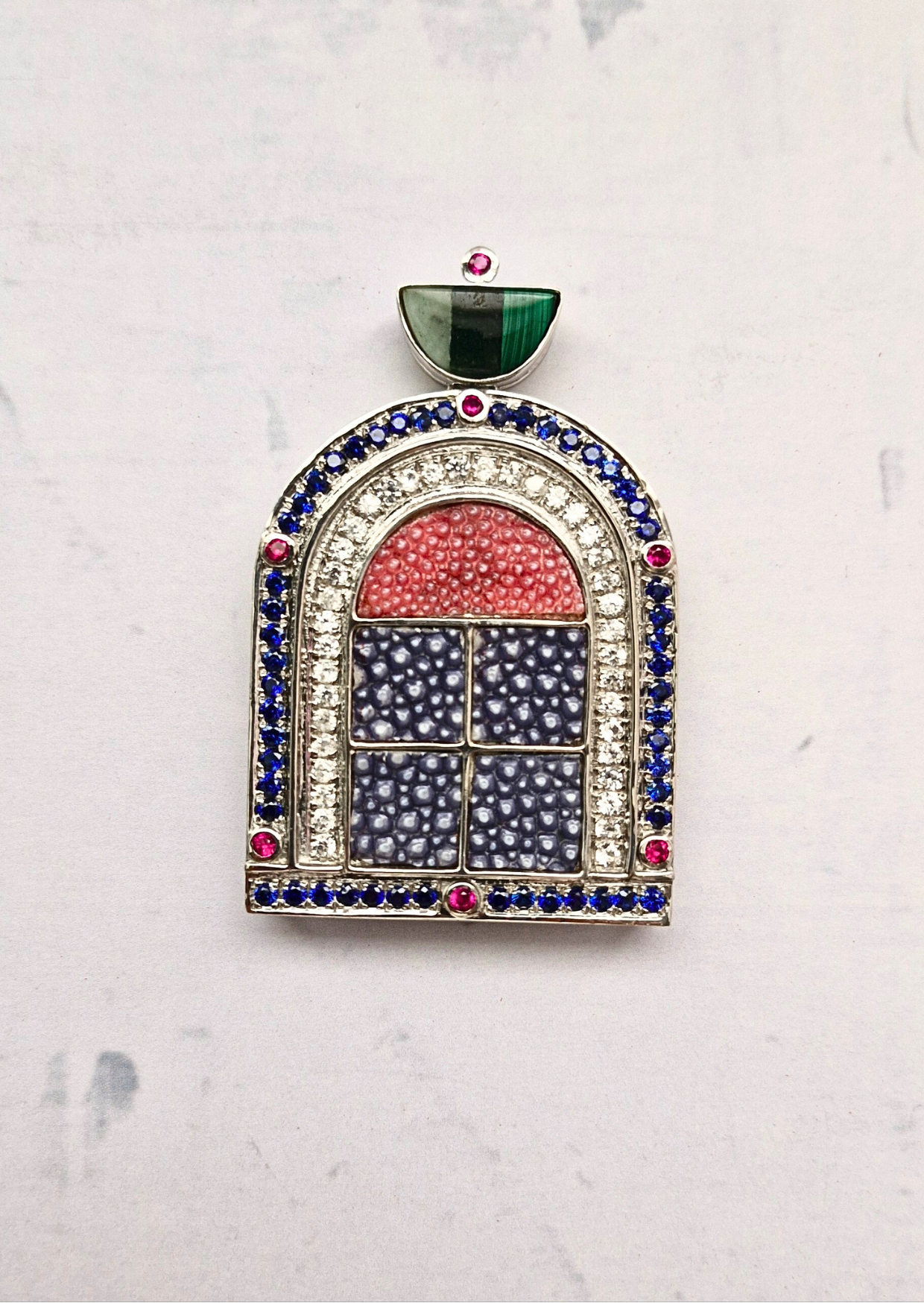Jewelry piece with multicolored gemstones on a light gray background