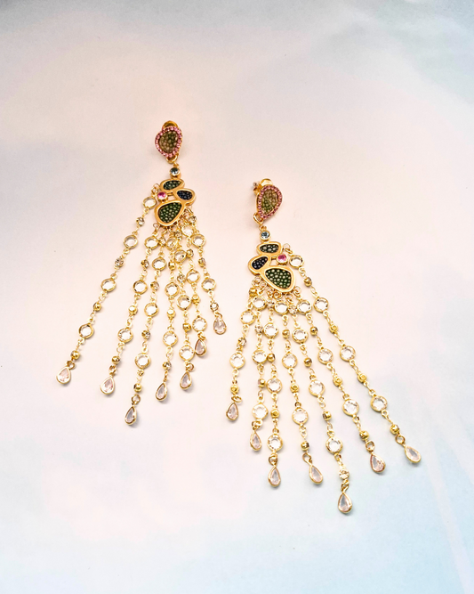 Gold jewelry with gemstones and stingray leather on a light blue background