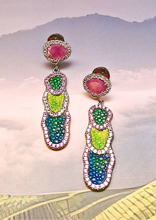Colorful earrings with gemstone-like beads on a light background